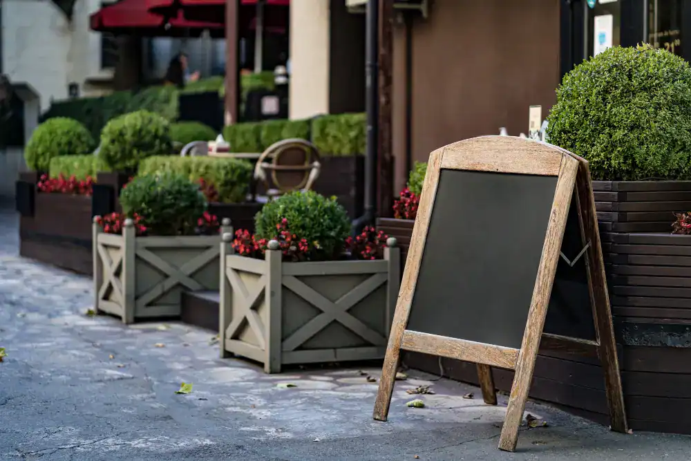 Außenwerbung eines Restaurants mit beleuchtetem Ausleger und Leuchtschriftzug am Eingang